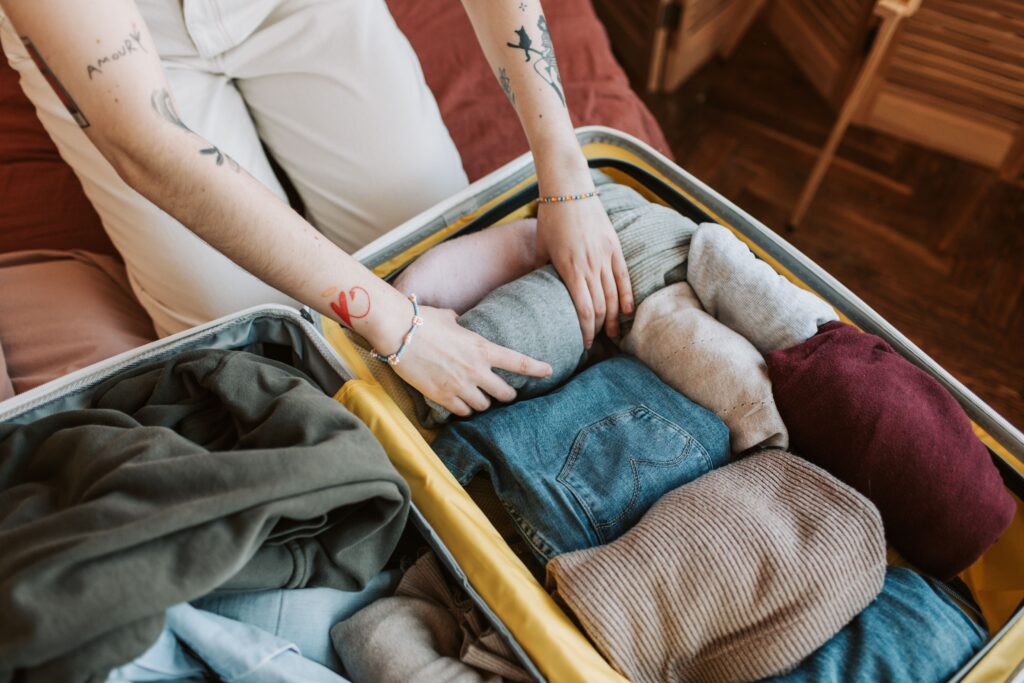 seguro de viaje para embarazadas - mujer embarazada haciendo la maleta antes de viajar